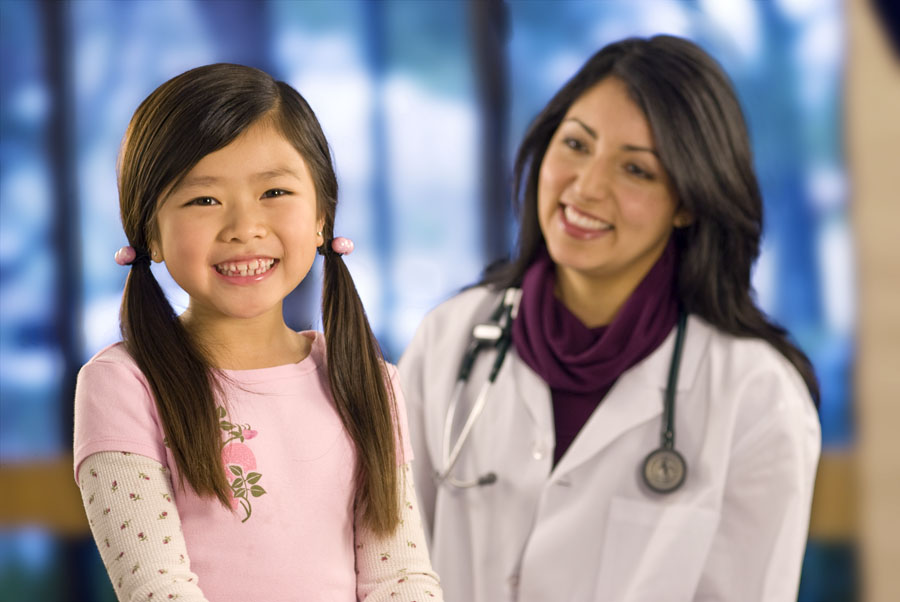 young girl and doctor smiling at camera